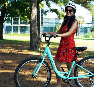 Woman smiling with her 27.5" WEEKEND ESCAPE 1.0 STEP-THRU bike